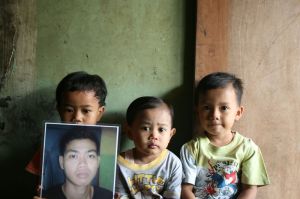 Relatives hold a picture of Yusli, killed in police custody